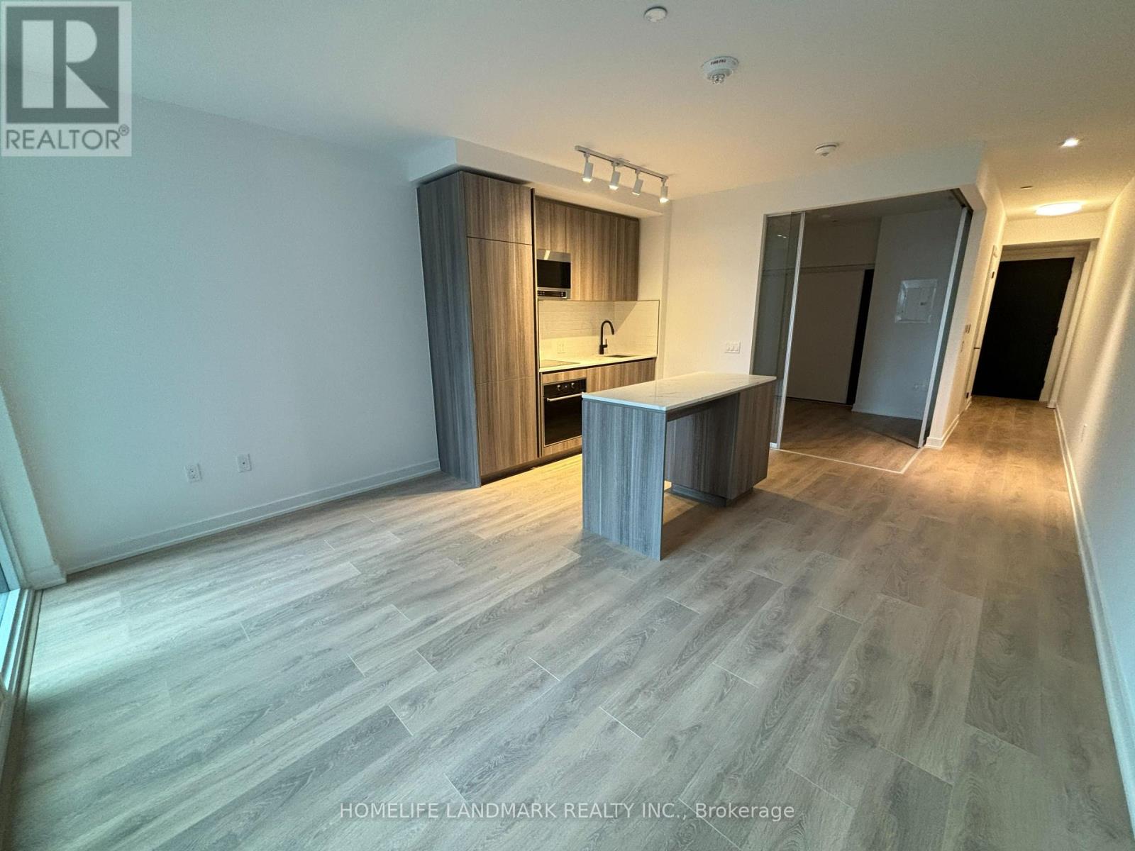 A spacious room with a kitchenette and a bar area.