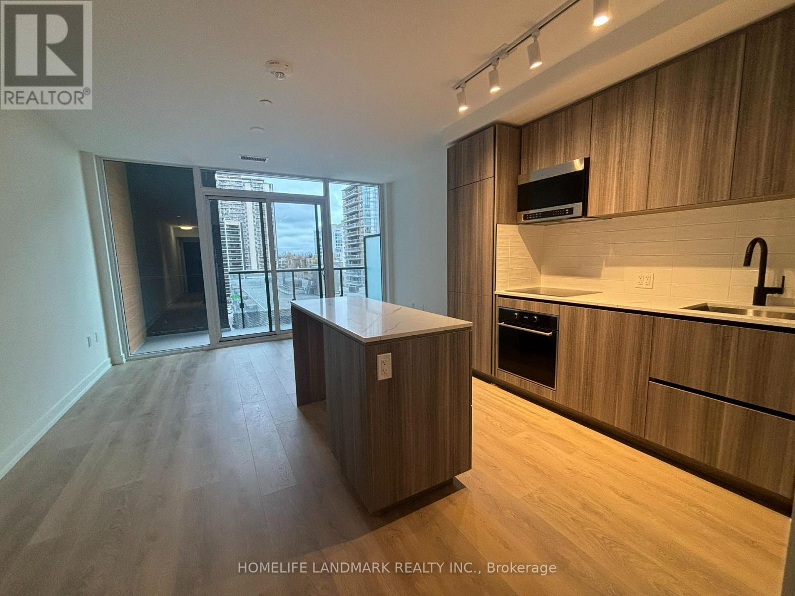 A modern kitchen with wooden cabinets and a large island.