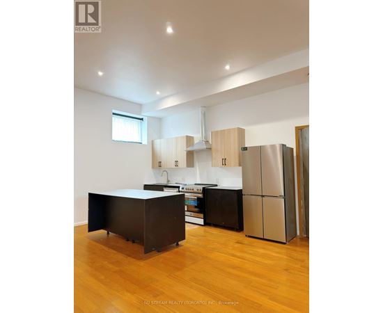 A kitchen with wooden cabinets and a black island.