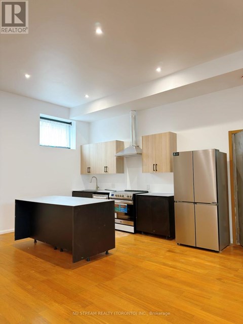 A kitchen with wooden cabinets and a black island.