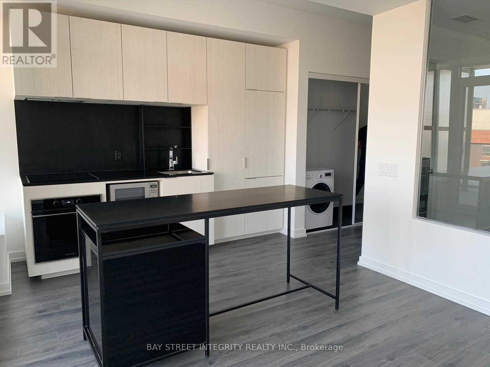 A kitchen with a black countertop and white cabinets.