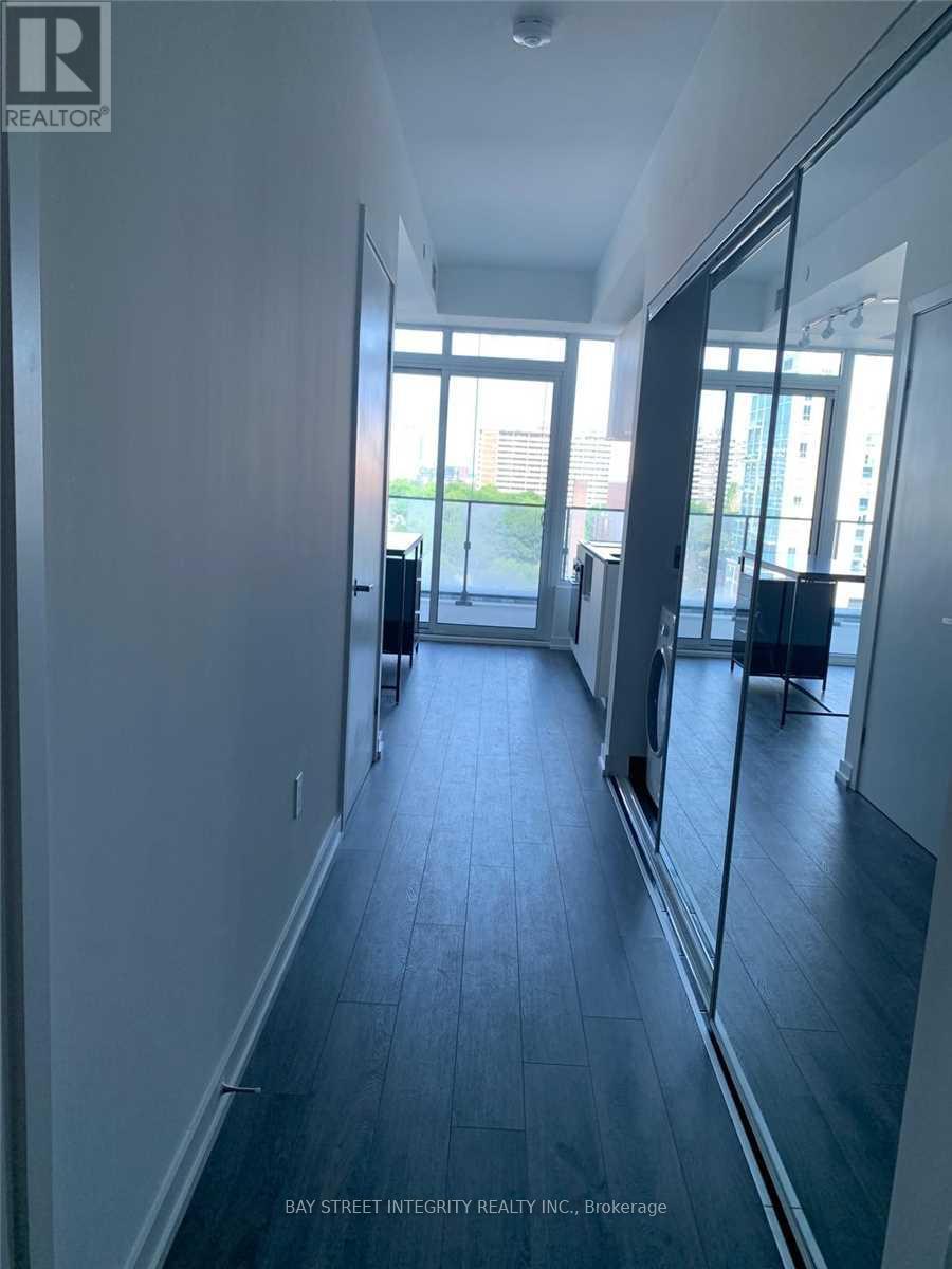 A long, narrow hallway with a glass door leading to a balcony.
