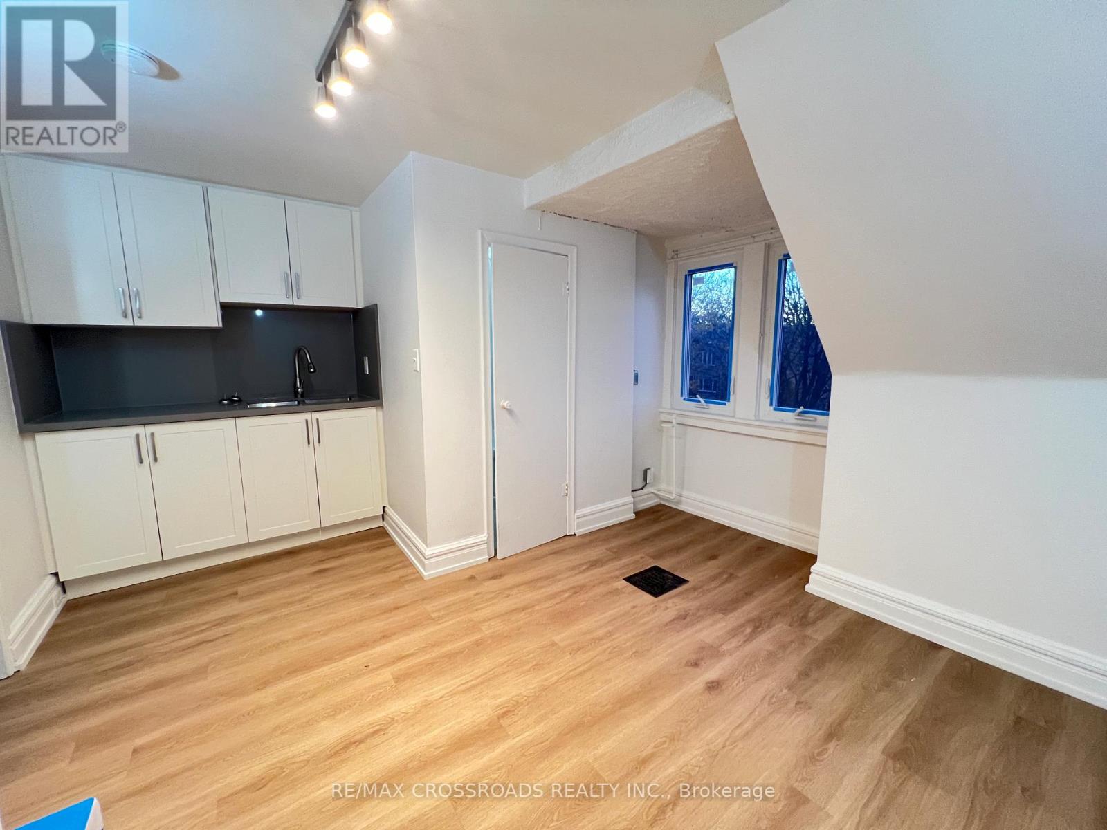A kitchen with white cabinets and a black countertop.