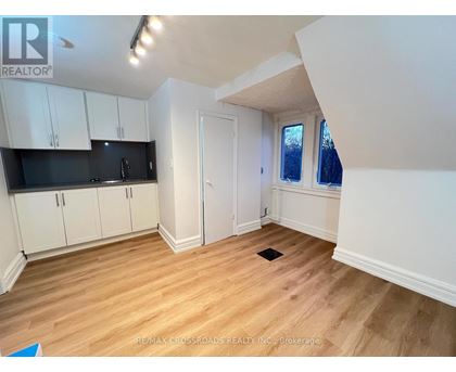 A kitchen with white cabinets and a black countertop.