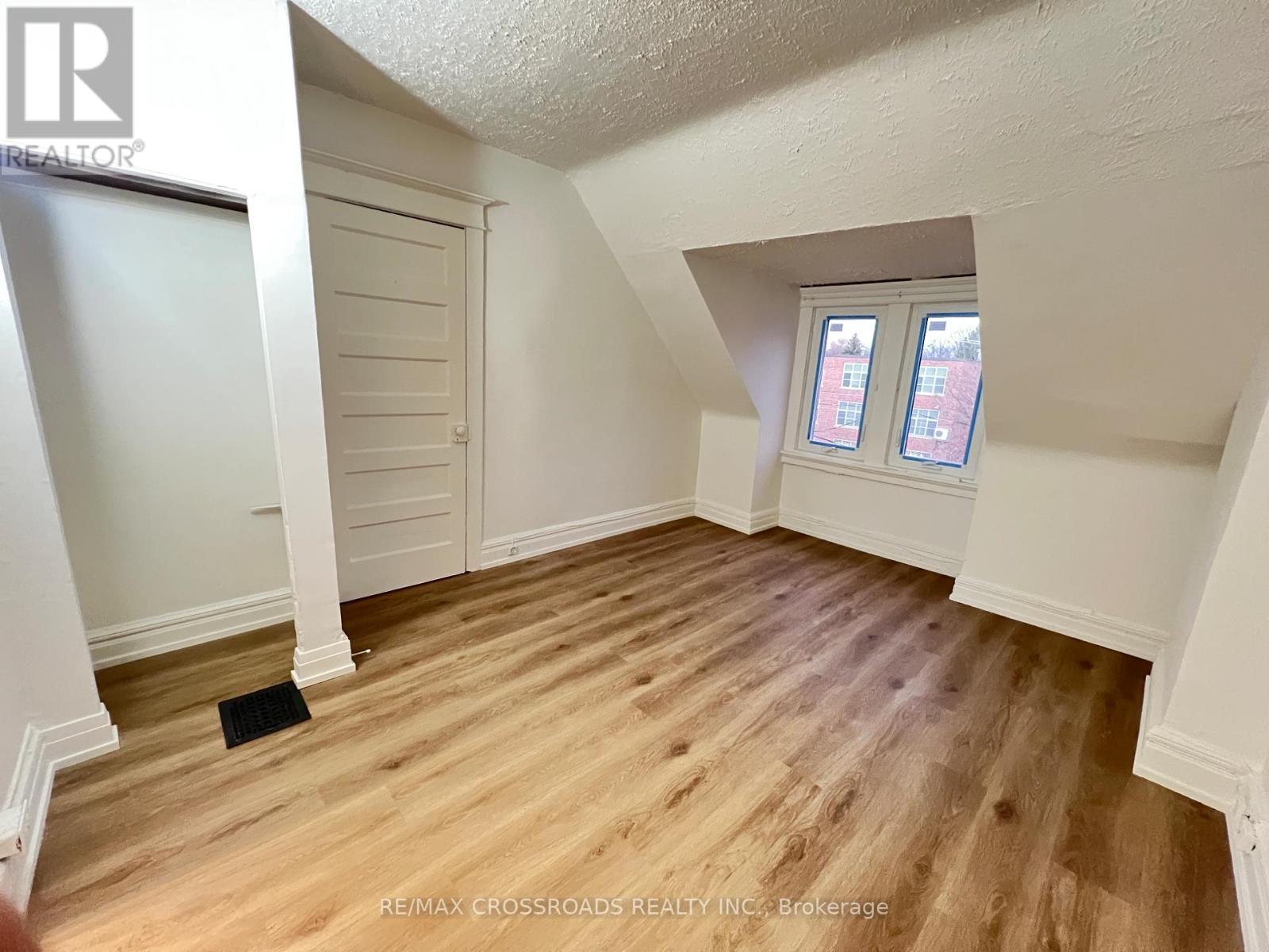 A room with wooden flooring and a window with two panes of glass.