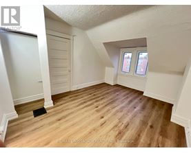 A room with wooden flooring and a window with two panes of glass.
