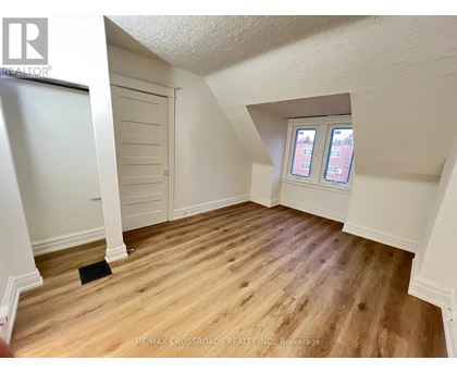 A room with wooden flooring and a window with two panes of glass.