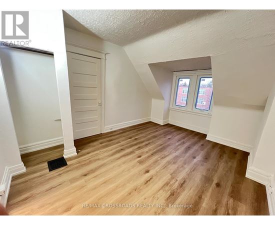 A room with wooden flooring and a window with two panes of glass.