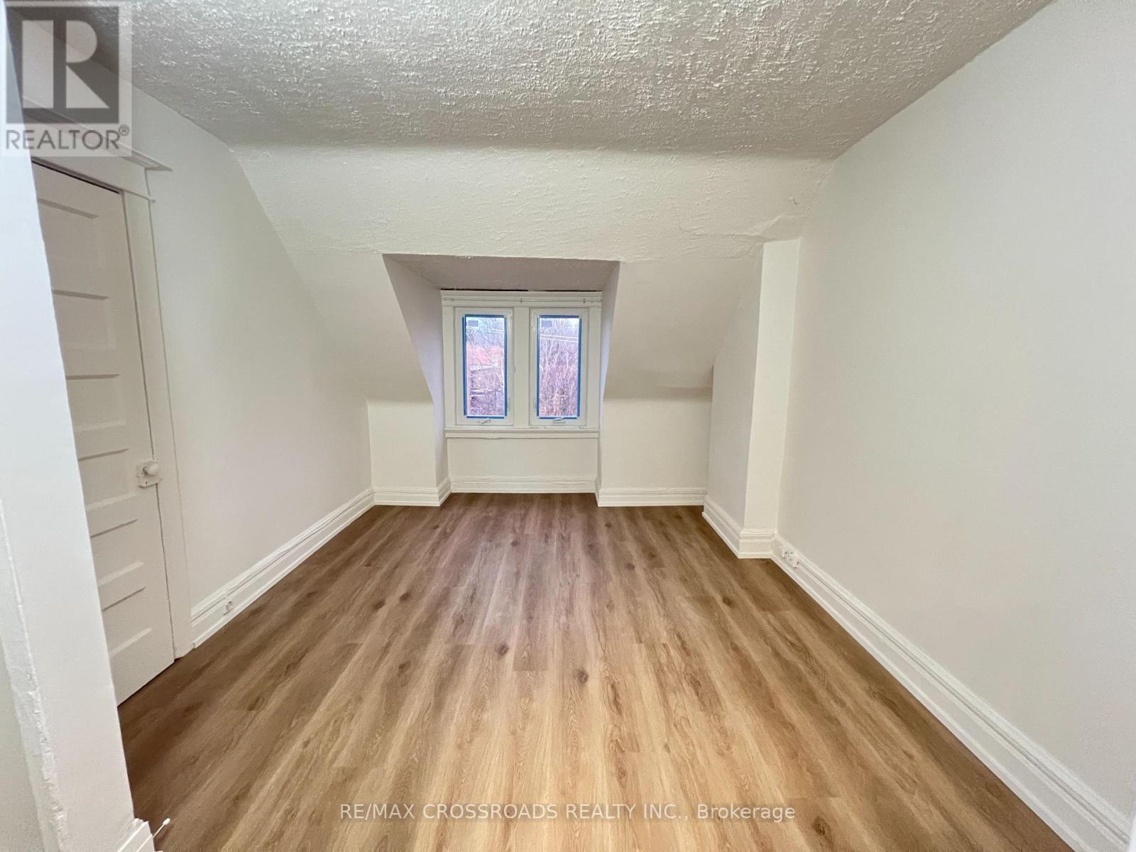 A room with wooden flooring and a window.