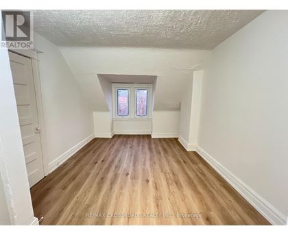 A room with wooden flooring and a window.