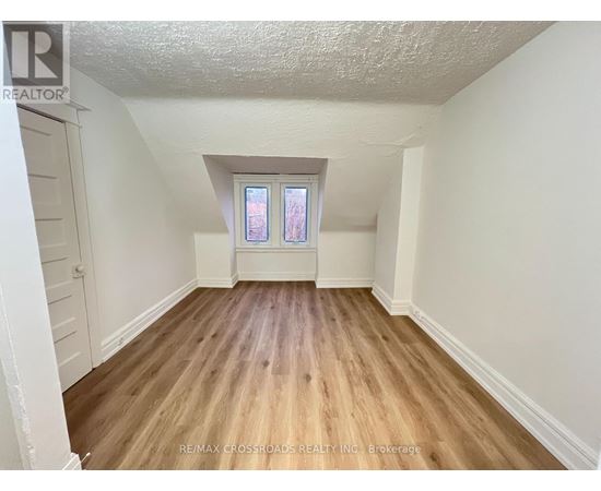 A room with wooden flooring and a window.