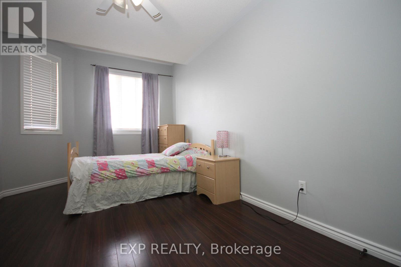 A bedroom with a bed, nightstand, and window.
