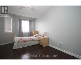 A bedroom with a bed, nightstand, and window.