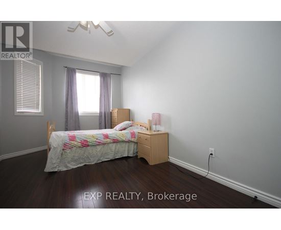 A bedroom with a bed, nightstand, and window.