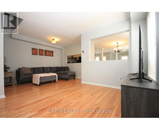 A living room with a grey couch and a wooden floor.