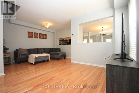 A living room with a grey couch and a wooden floor.