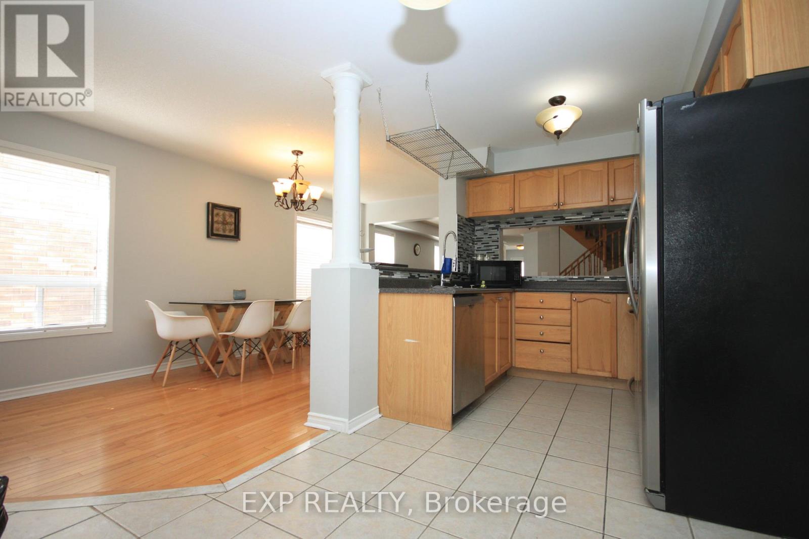 A kitchen with wooden cabinets and a black refrigerator.