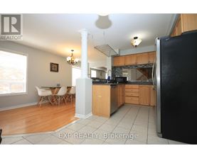 A kitchen with wooden cabinets and a black refrigerator.