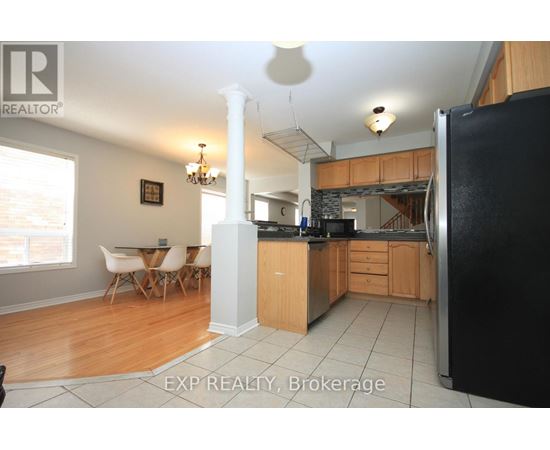 A kitchen with wooden cabinets and a black refrigerator.