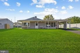 A house with a grey roof and a green lawn in front.