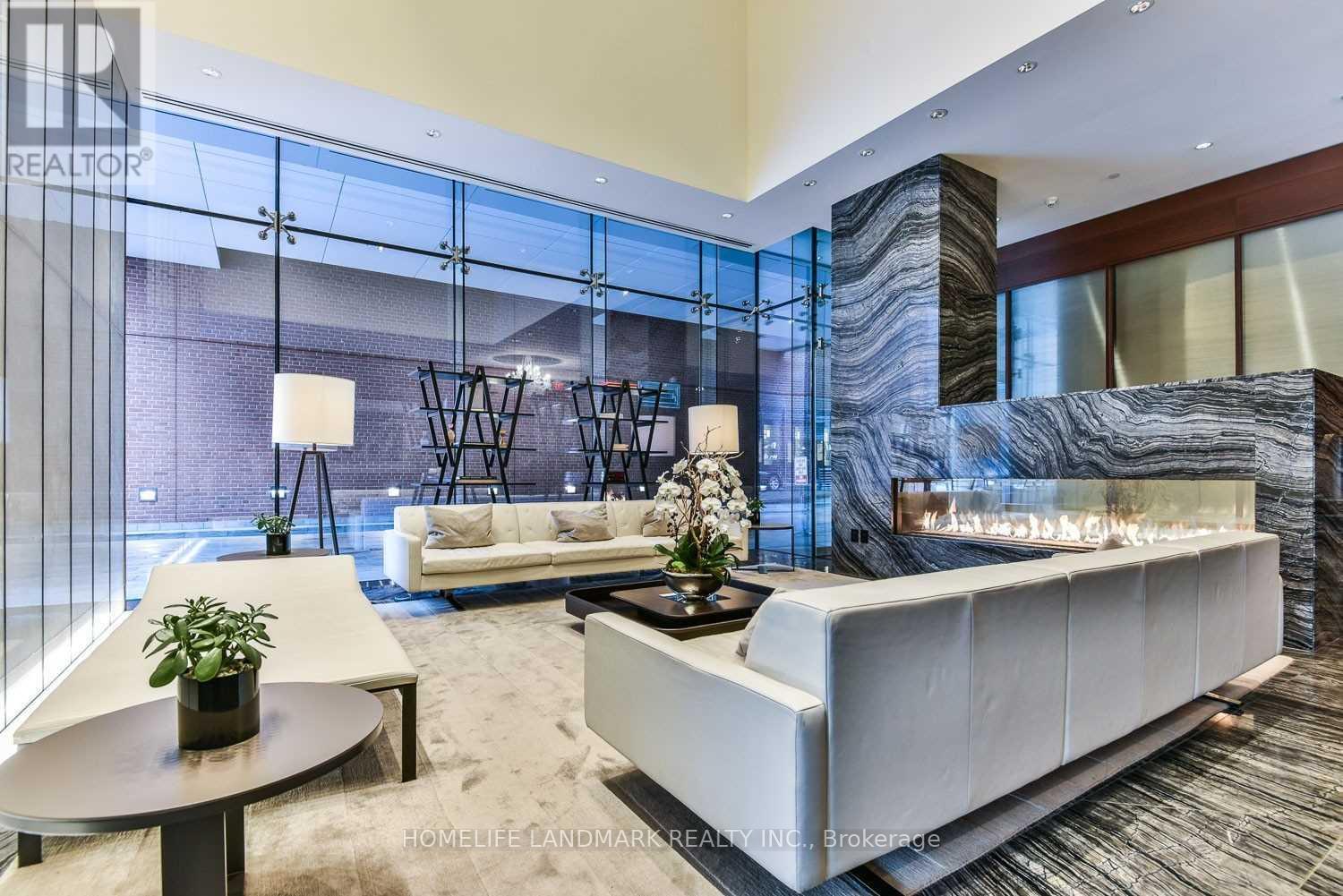 A modern living room with a glass wall and a marble column.