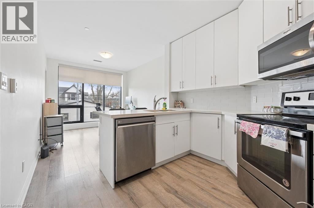 A modern kitchen with white cabinets and a wooden floor.