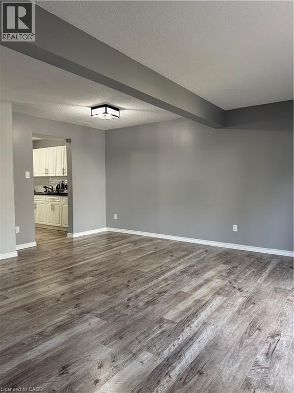 A room with wooden flooring and a white door in the background.