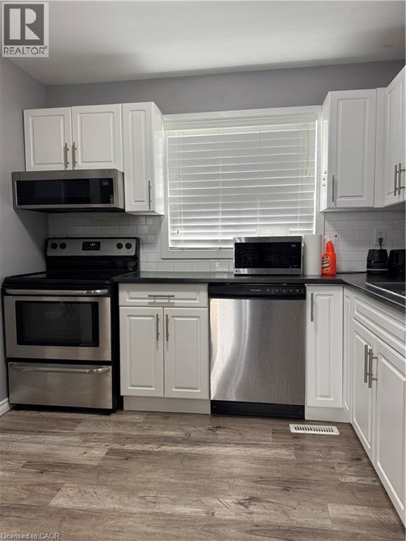 A kitchen with white cabinets and stainless steel appliances.