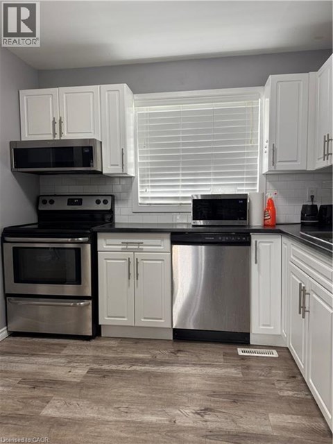 A kitchen with white cabinets and stainless steel appliances.