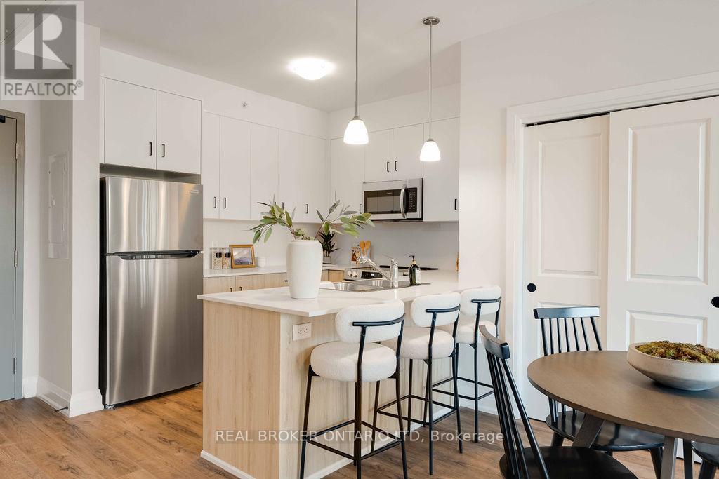A modern kitchen with a stainless steel refrigerator and white cabinets.