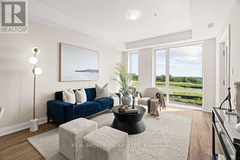 A living room with a blue sofa and a large window overlooking a green landscape.
