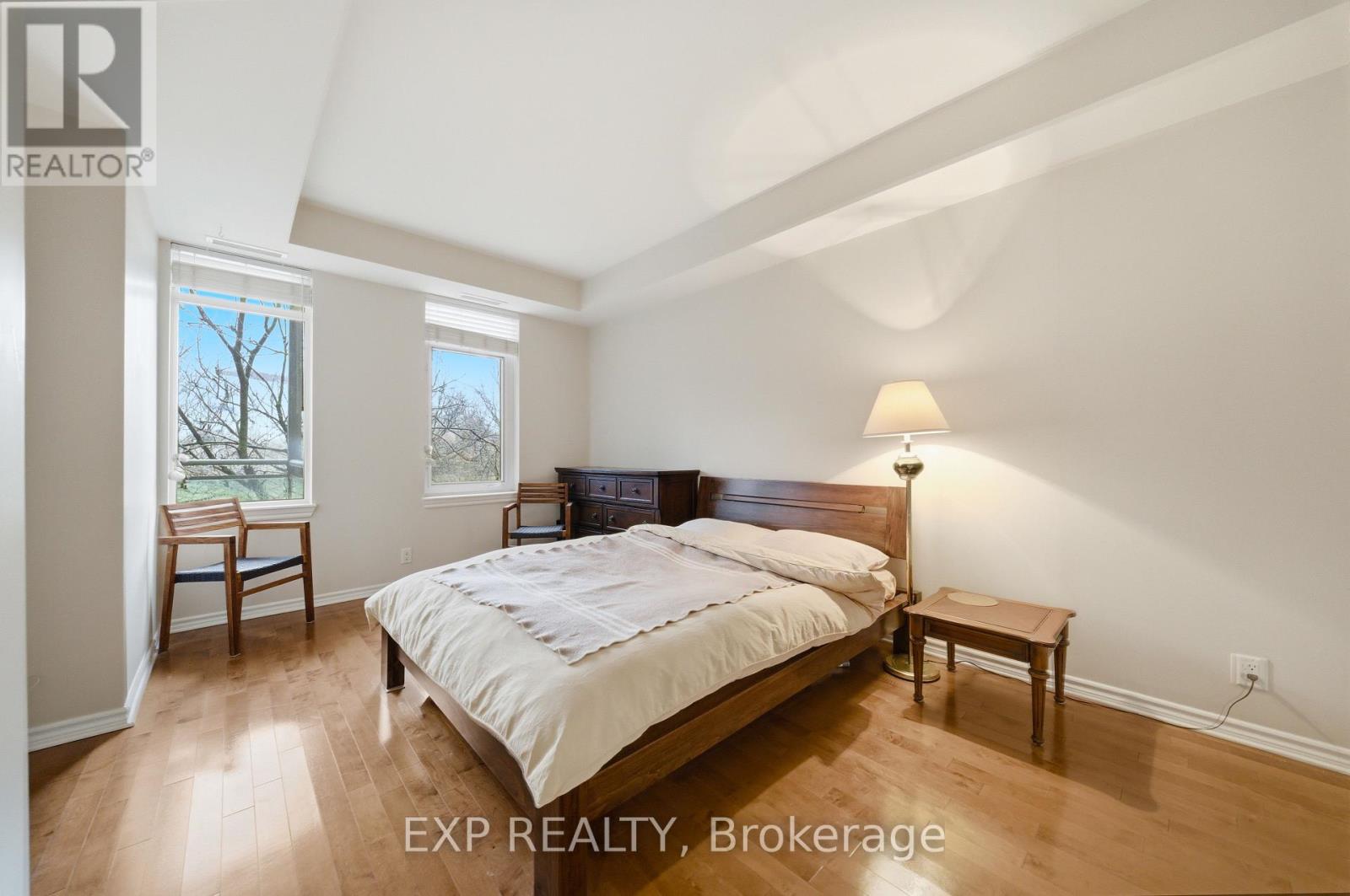A bedroom with a bed, nightstand, and chair.