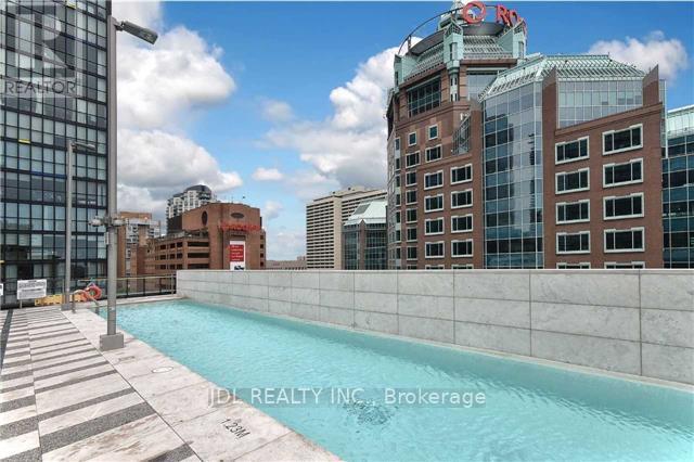 A pool area with a sign that says "IDL REALTY INC. Brokerage".