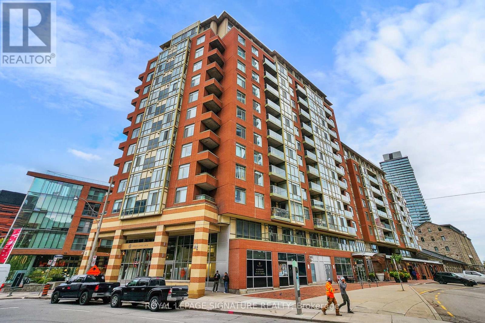 A tall building with a red brick facade and a glass window on the second floor.
