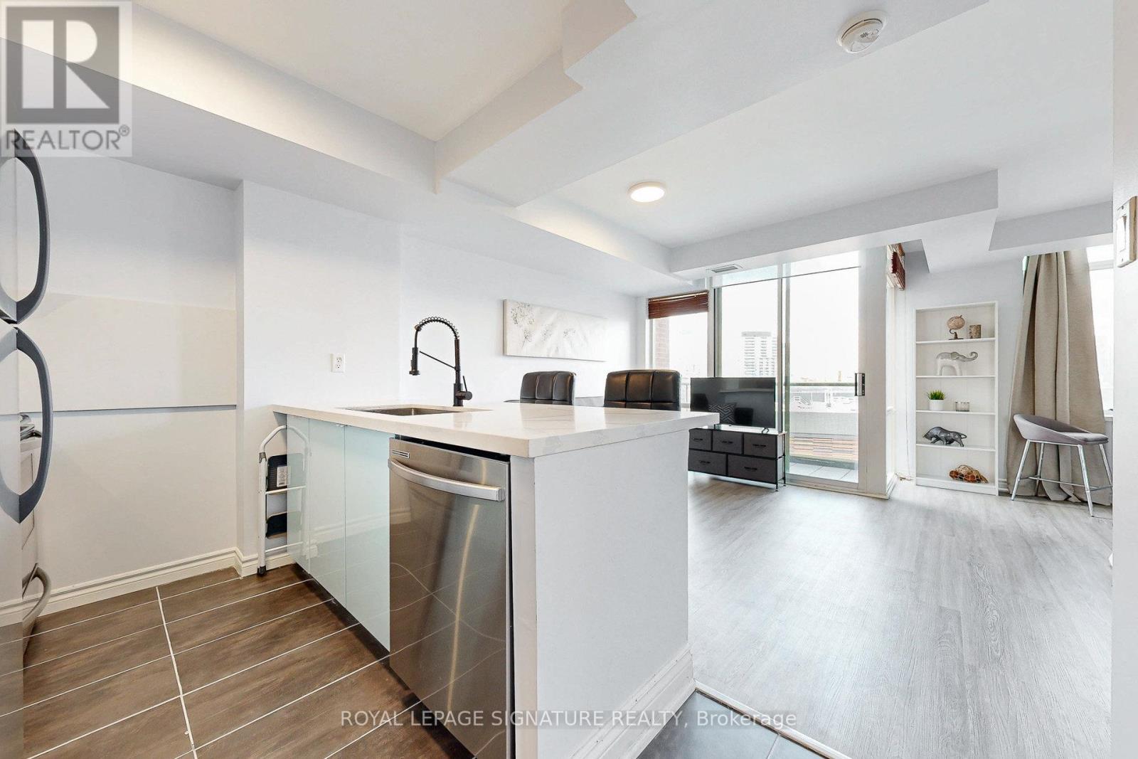 A modern kitchen with a large island and stainless steel appliances.