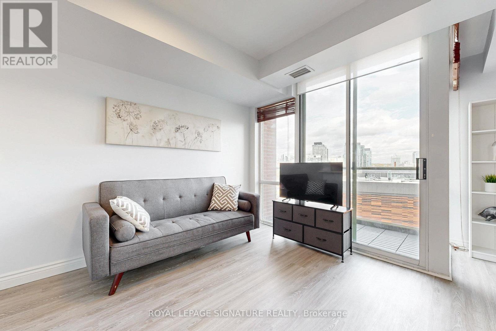 A living room with a grey couch and a television.