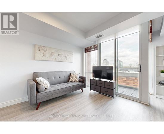 A living room with a grey couch and a television.