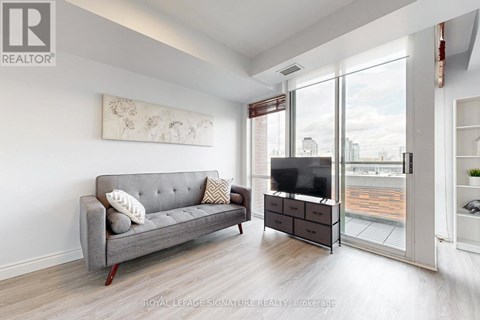 A living room with a grey couch and a television.