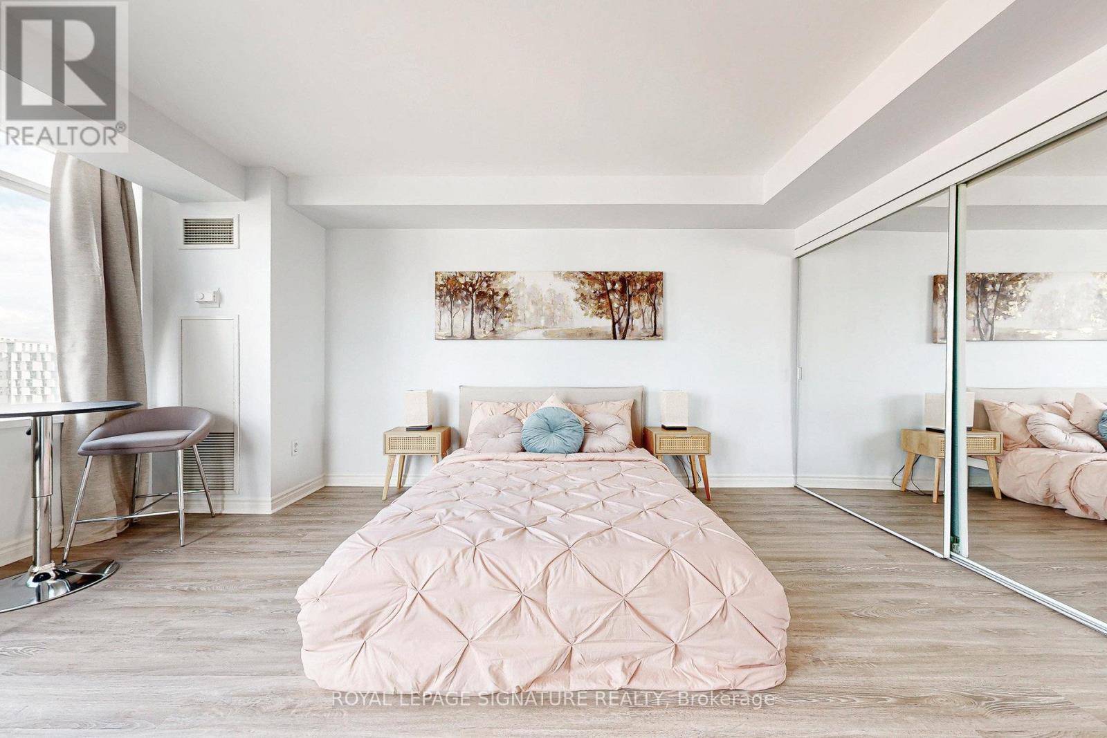 A bedroom with a large bed and a mirror on the wall.