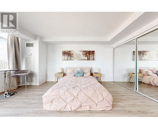 A bedroom with a large bed and a mirror on the wall.