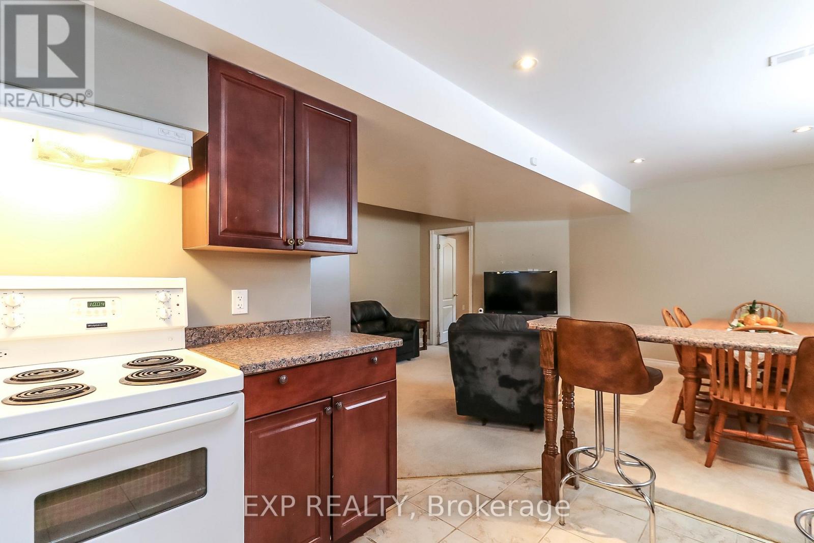 A kitchen with a stove top oven and a dining table with chairs.