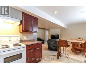 A kitchen with a stove top oven and a dining table with chairs.