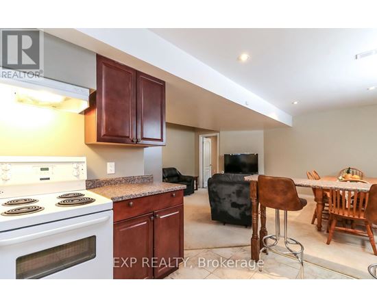 A kitchen with a stove top oven and a dining table with chairs.