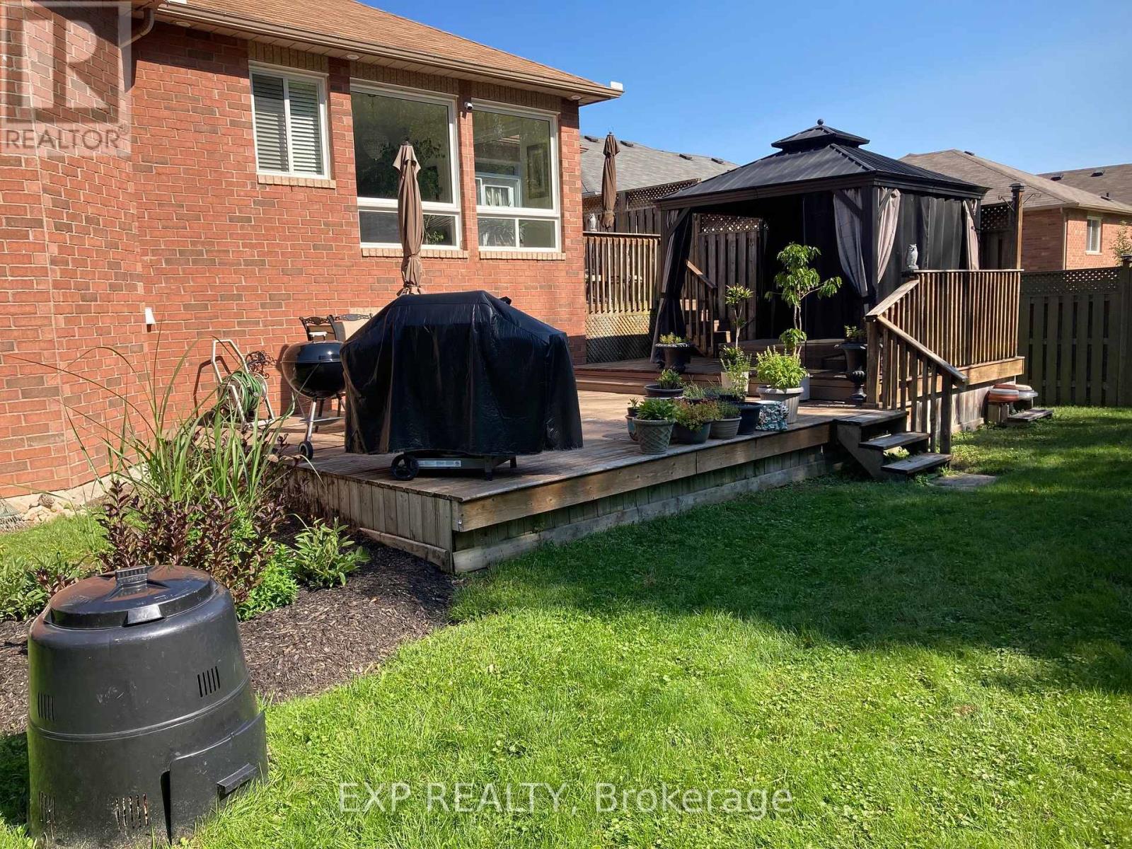 A backyard with a deck and a gazebo.