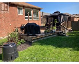 A backyard with a deck and a gazebo.