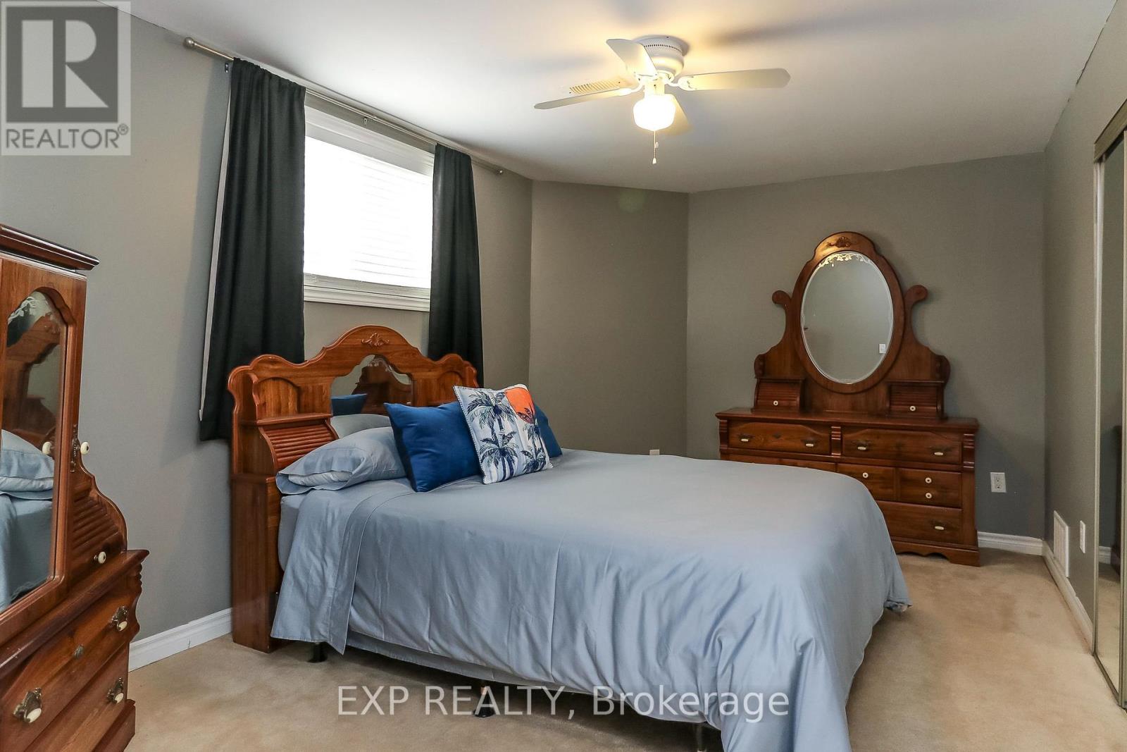 A bedroom with a bed, dresser, and mirror.
