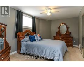 A bedroom with a bed, dresser, and mirror.