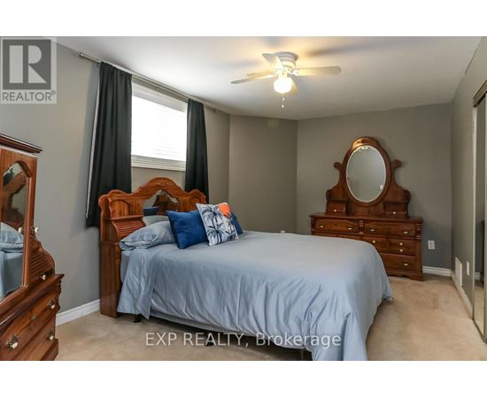 A bedroom with a bed, dresser, and mirror.