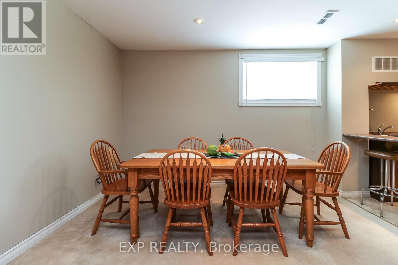 A dining room with a table and chairs.
