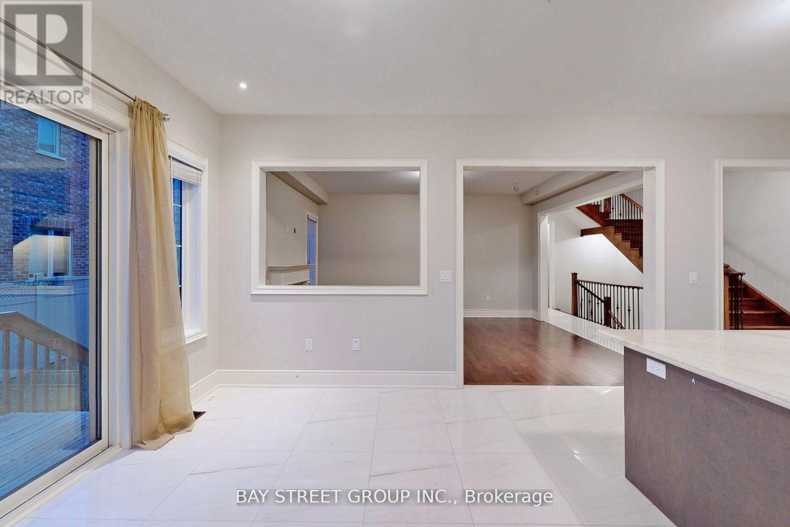 A spacious living room with a staircase leading to the upper floor.